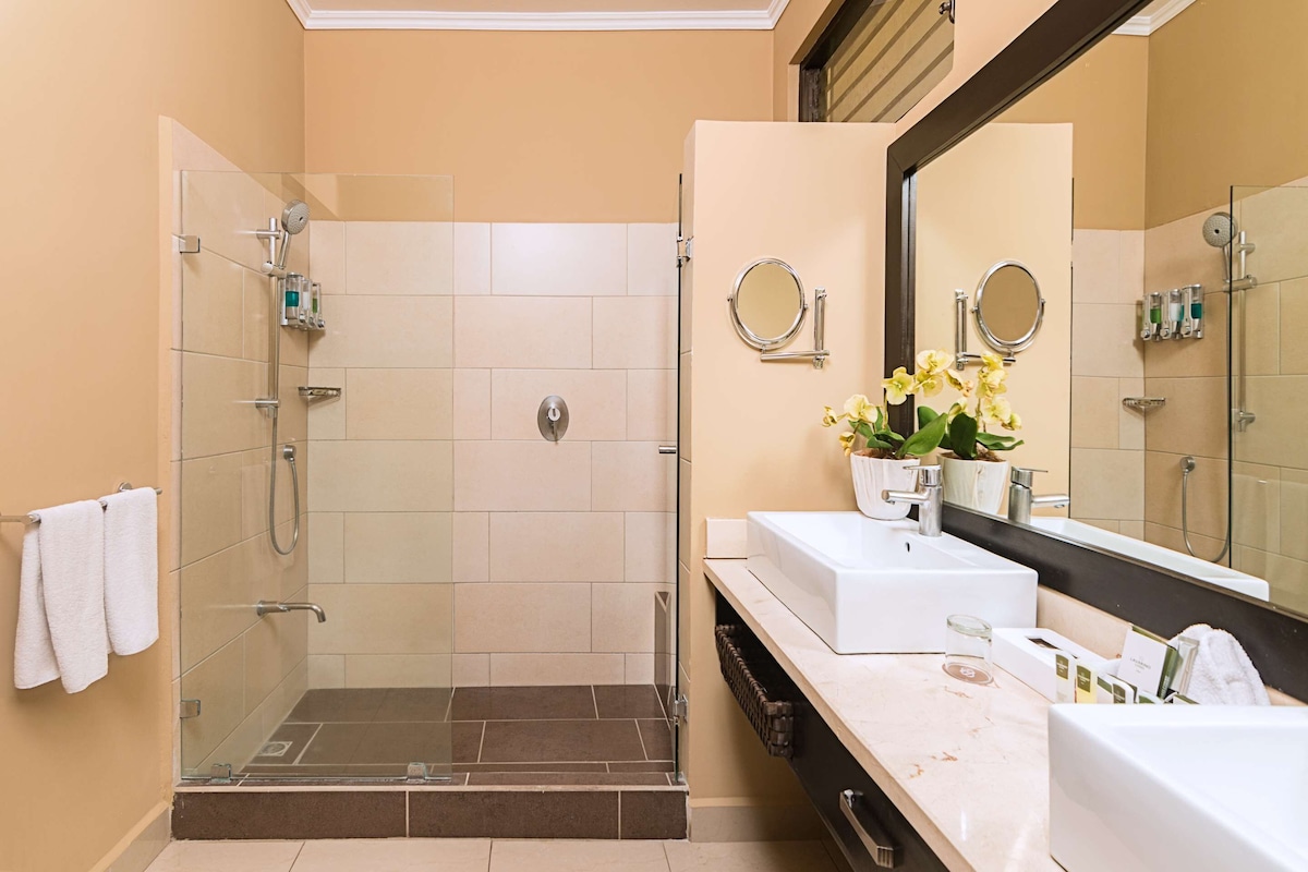 Bathroom features a glass-enclosed shower, sink, and vanity with a countertop.