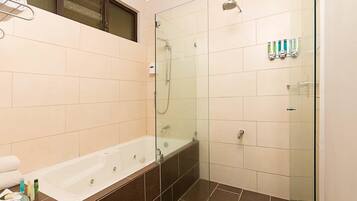 A modern bathroom with a glass-enclosed shower, a bathtub, and a toilet.