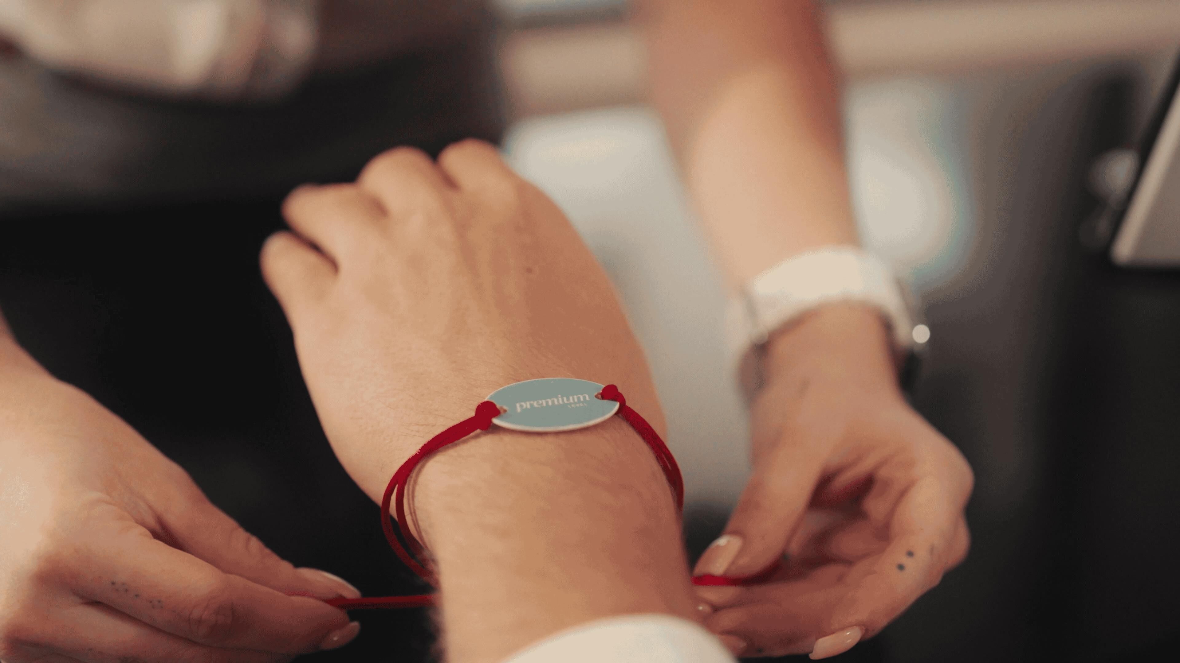 Uma pulseira com uma etiqueta rotulada como 'premium' sendo colocada no pulso.