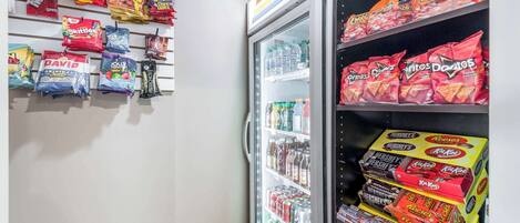 A snack display with various brands like Twix, Skittles, and Doritos.