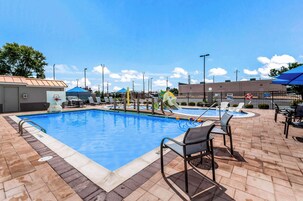 Una piscina al aire libre, sombrillas, tumbonas