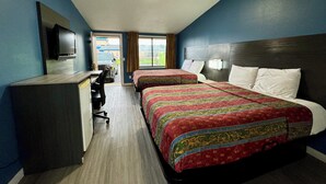 A hotel room with two beds, a desk, and a television. - Knights Inn Greenville, NC (Greenville)
