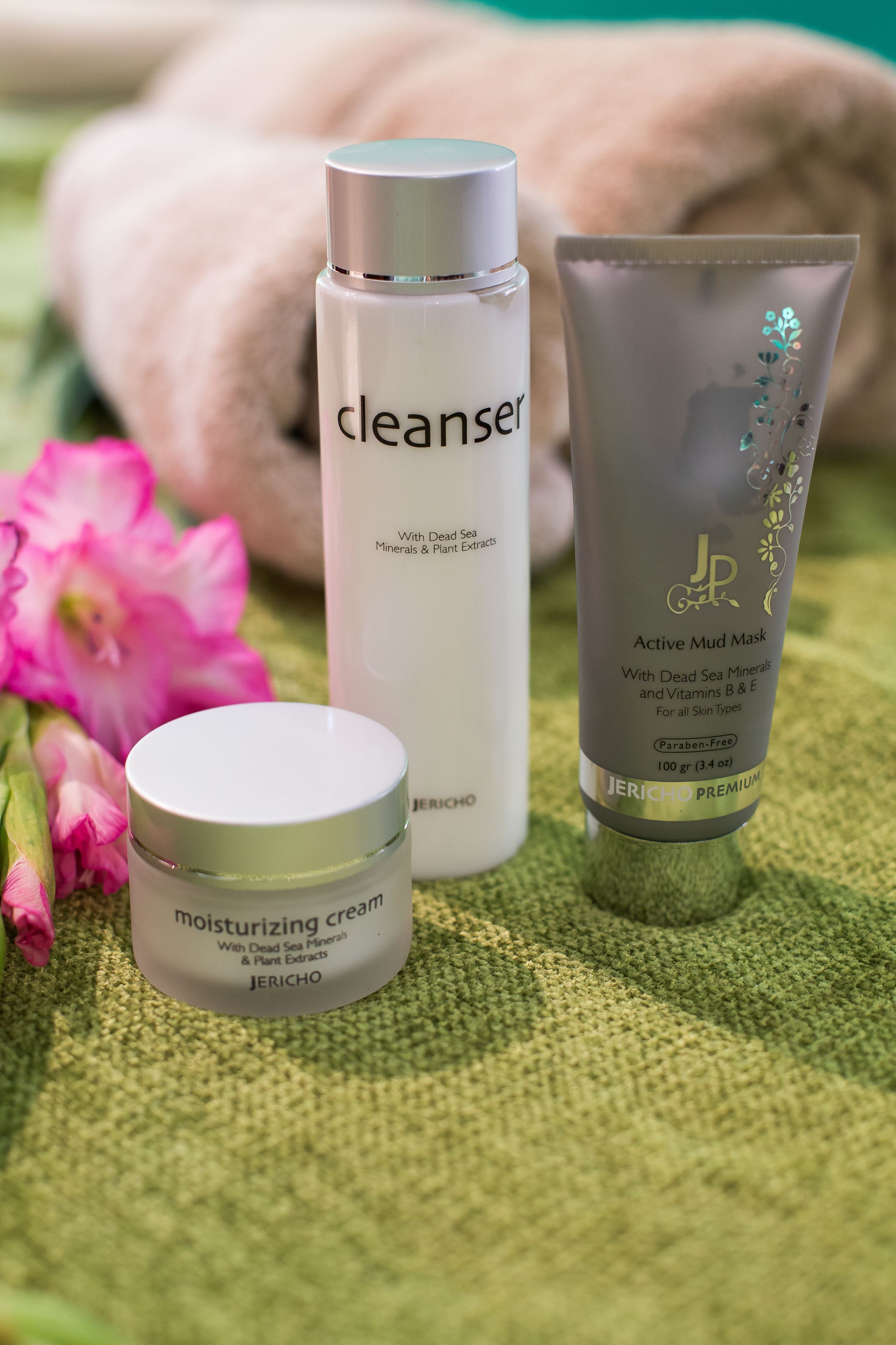 A skincare product display with a cleanser, an active mud mask, and a moisturizing cream.