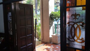 A doorway with a wooden door and a glass door with a decorative emblem.