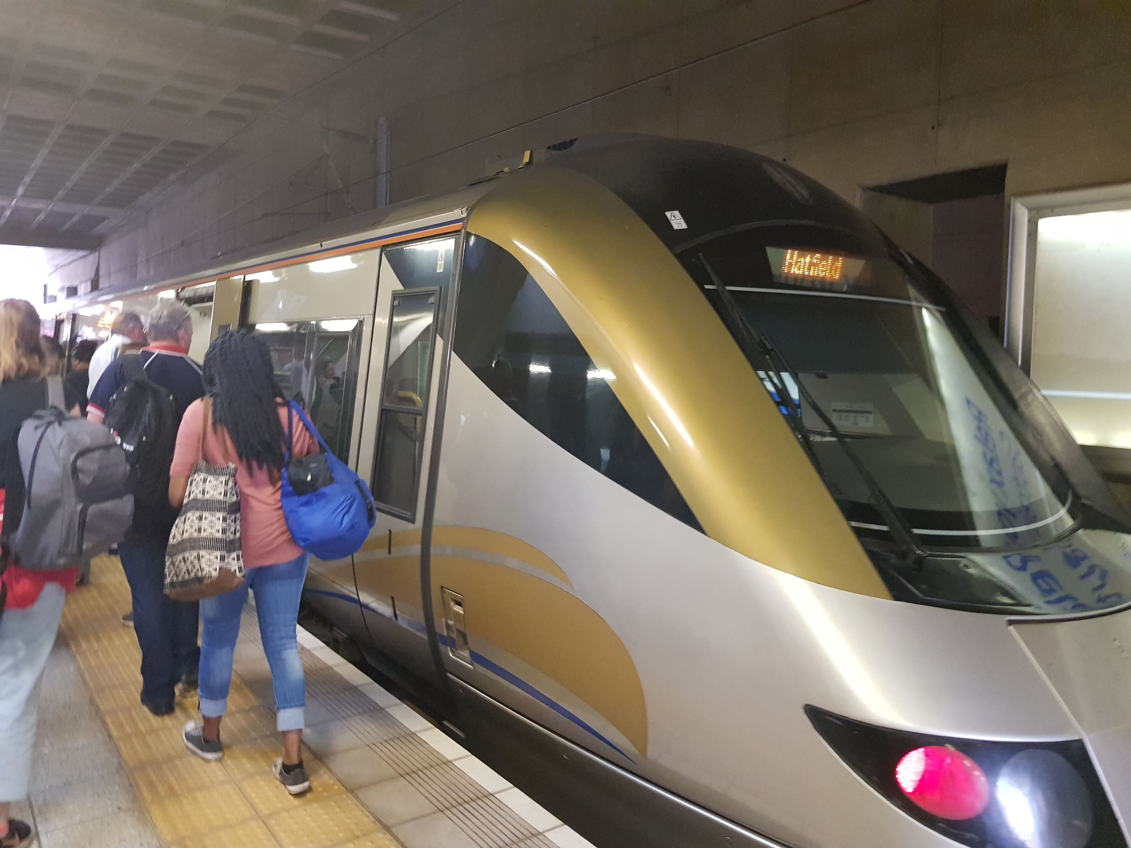 A train at a station platform with passengers boarding.
