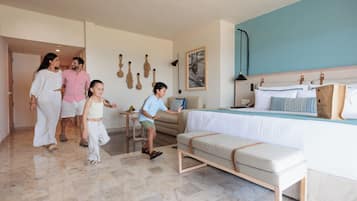 Una habitación de hotel con una cama, un banco, una mesita y una lámpara fijada a la pared.
