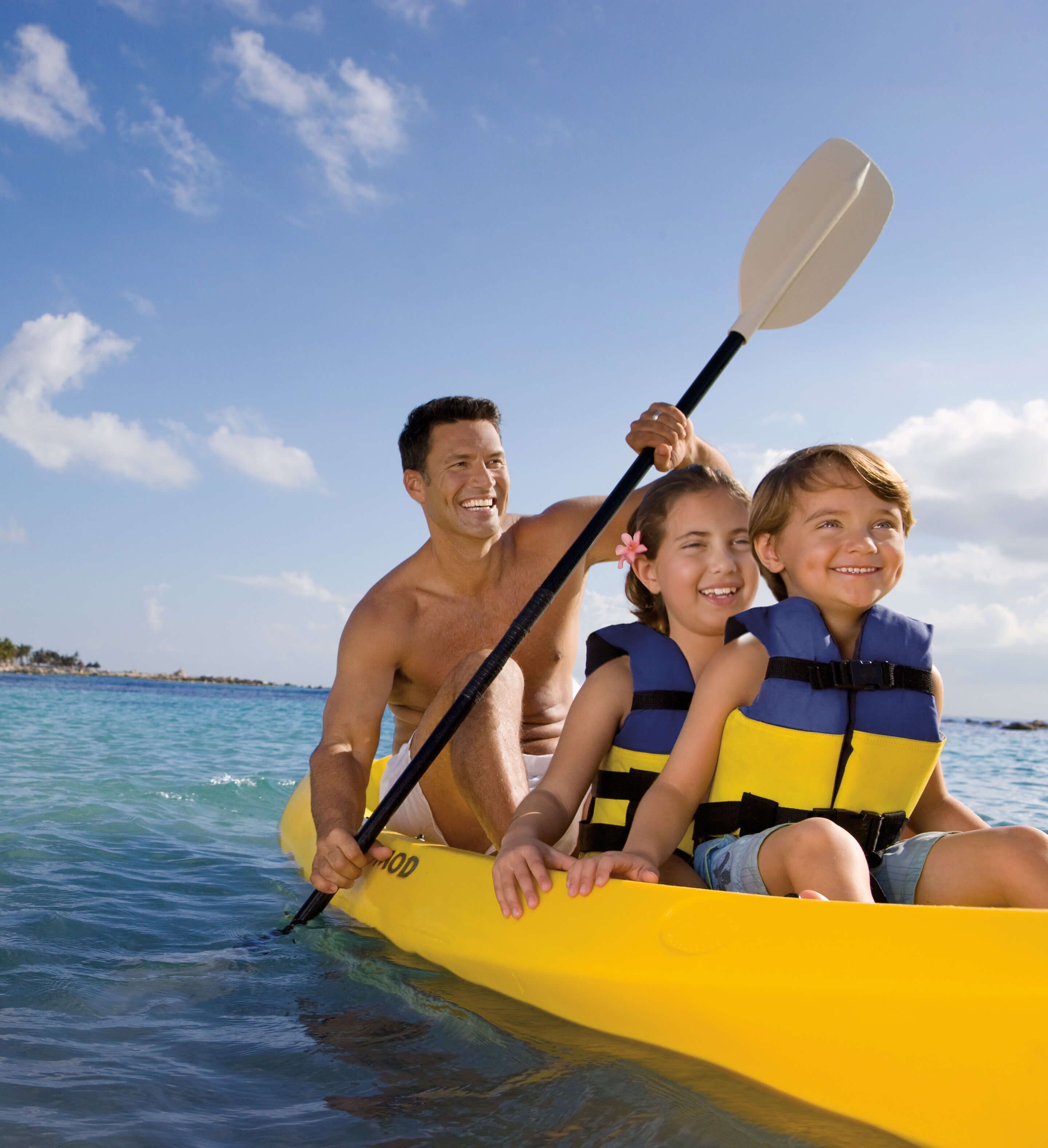 Una familia en un kayak amarillo en aguas tranquilas.