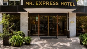 La entrada del Hotel Mr. Express con un cartel grande sobre las puertas, un acceso de vidrio y el número 40 en la fachada del edificio.