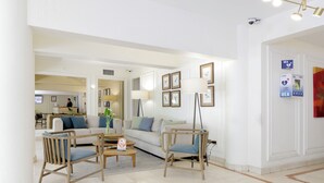 Amplia sala de estar con un sofá, dos sillones, una mesa de centro y una lámpara de pie.