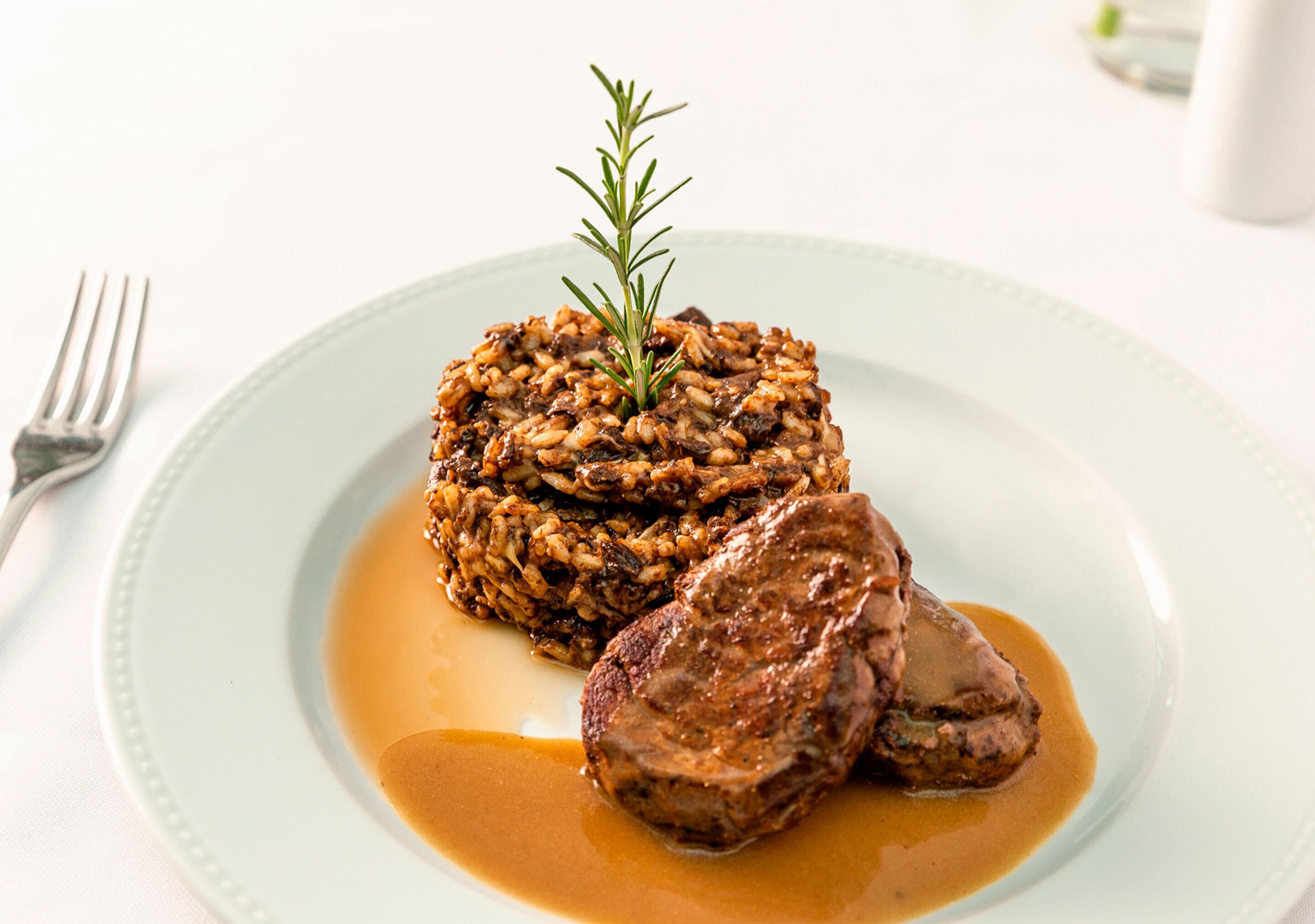 A plate with a meat dish and a side of rice.