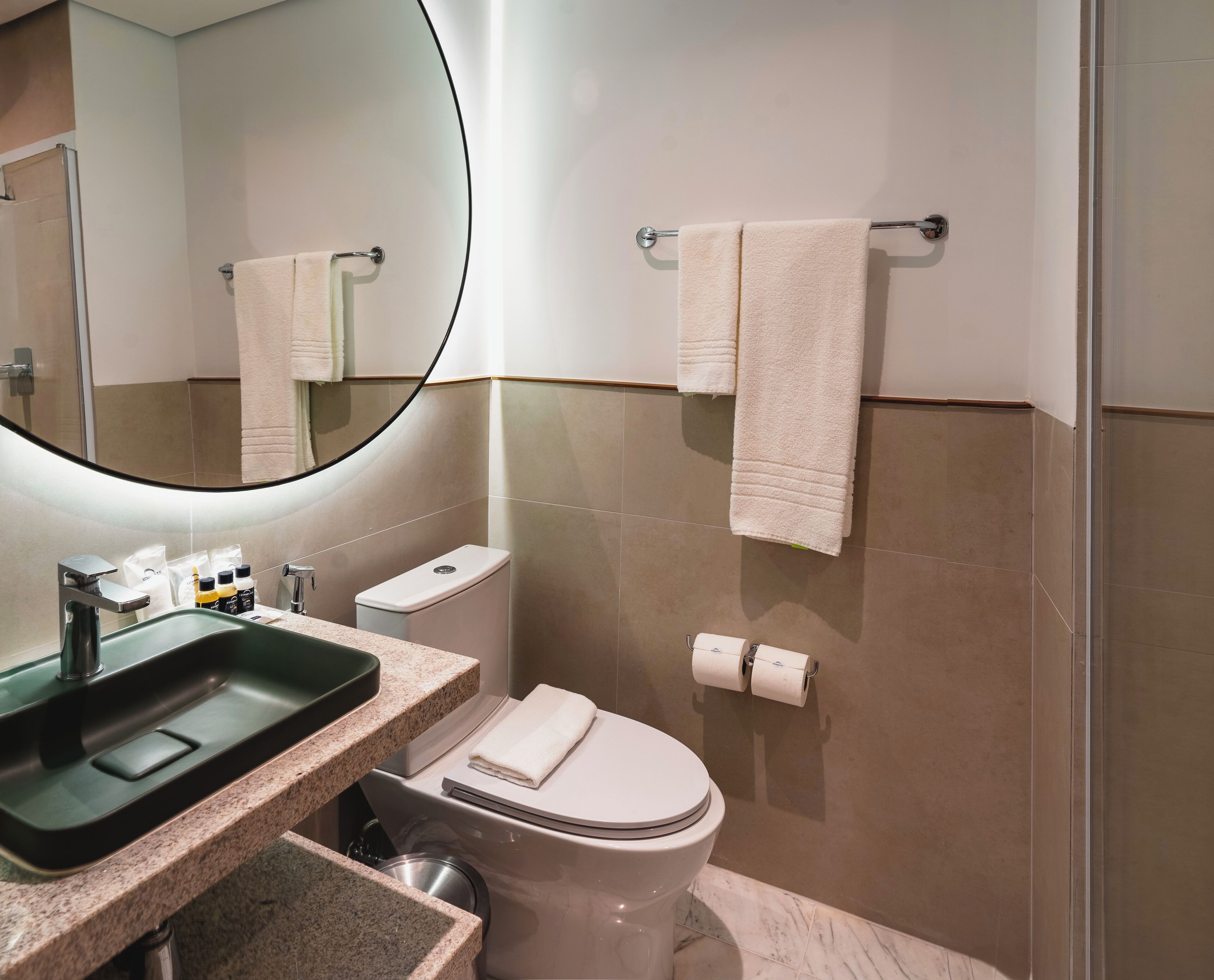 Une salle de bain moderne avec un lavabo, des toilettes et un miroir.