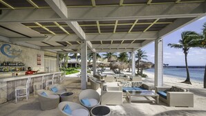 A beachside bar with wicker furniture and a view of the ocean. - Catalonia Riviera Maya Resort and Spa All Inclusive (Puerto Aventuras)
