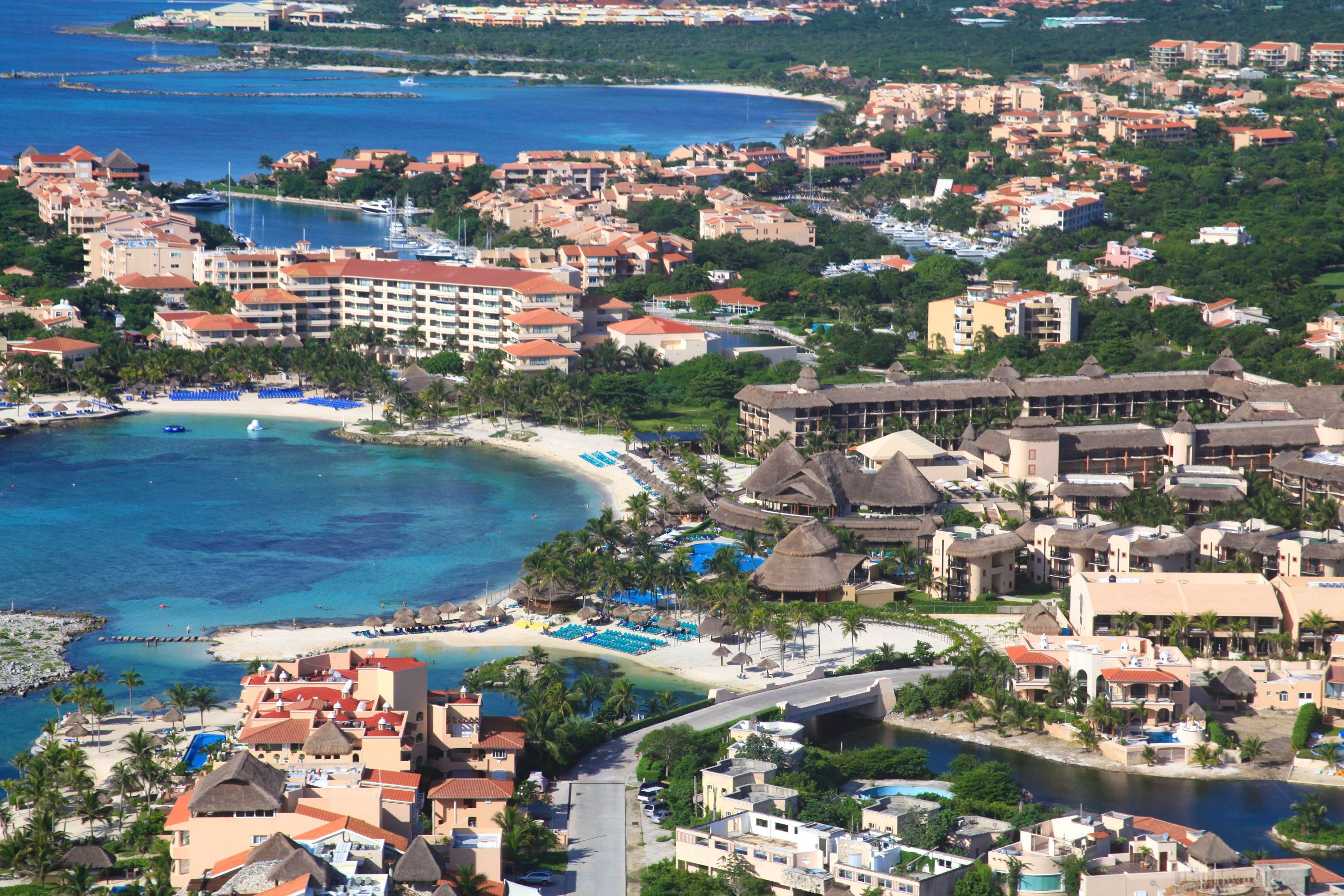 A coastal resort with beachfront villas, a marina, and a pool area.