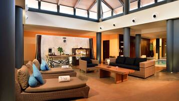 Welcome to our lobby, featuring a reception desk, comfortable seating area and a pool in the background.