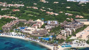 Luchtbeeld van een resort met meerdere gebouwen, een strand en een zwembad.