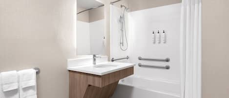 Ein modernes Badezimmer mit einem Holzbadezimmerhocker, einem großen Spiegel, einer Badewanne und einer Dusche.