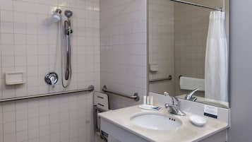 Un baño moderno con ducha, lavabo y espejo.
