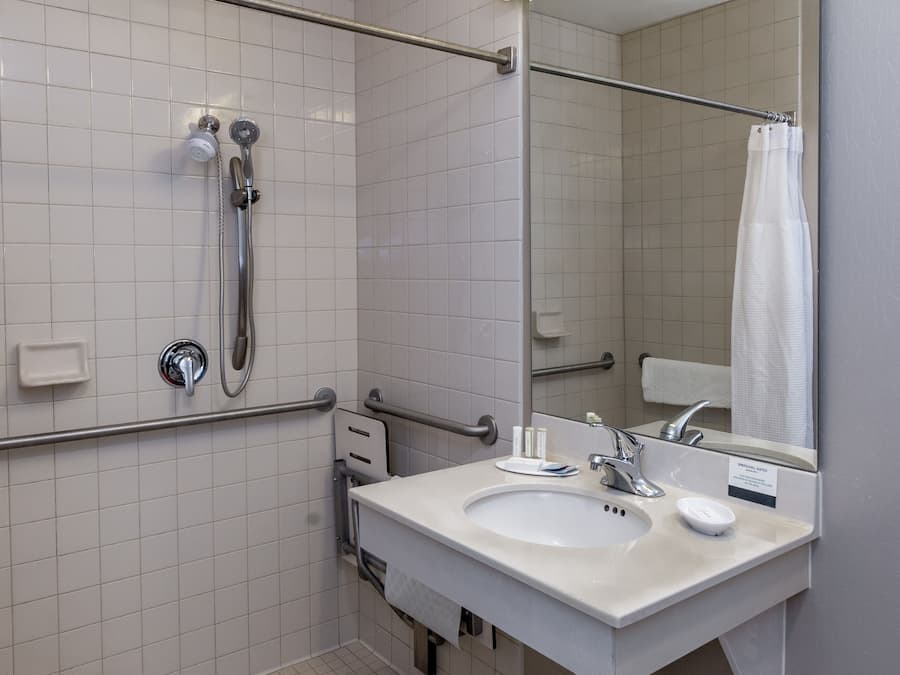 Un baño moderno con ducha, lavabo y espejo.
