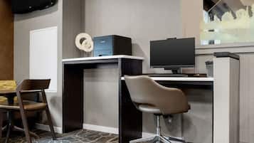 A modern office space with a desk, chair, computer, and printer.