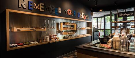 A bakery counter with a sign that reads "REMEMBER YOUR DREAMS" and a display of baked goods.
