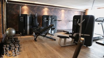 A gym with exercise equipment, including a bench press, a leg press, and a treadmill.