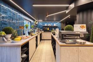 Eine moderne Küche mit einer zentralen Kochinsel, einer Kaffeemaschine und einer Speisekarte.