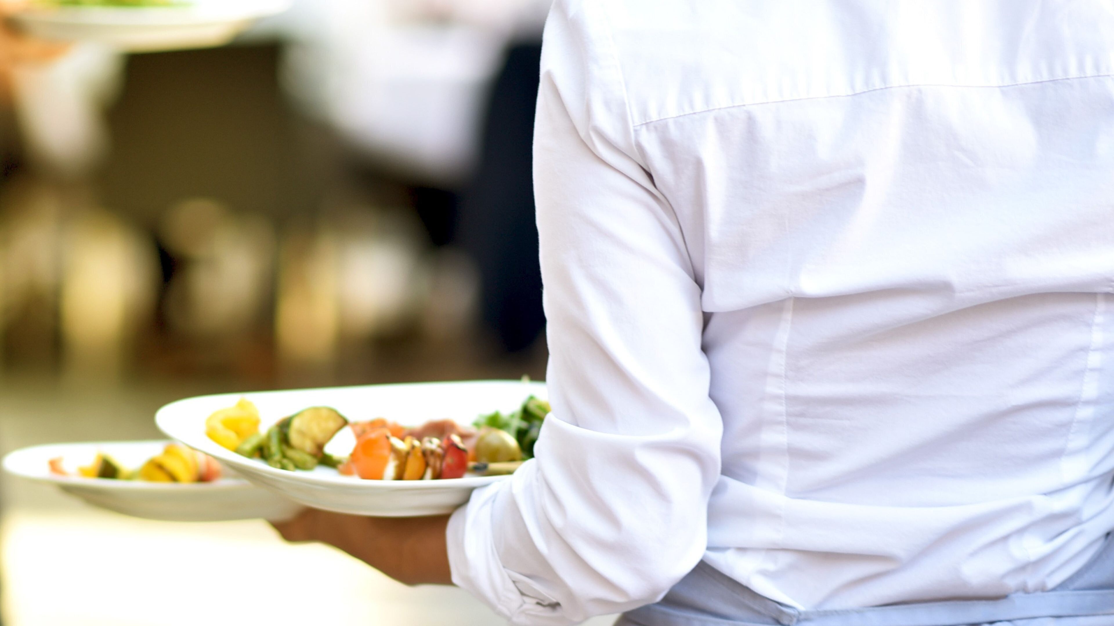 Una persona sosteniendo un plato con ensalada.