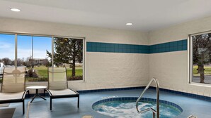 A spa area with a hot tub, seating, and large windows offering a view of the outdoors. - Comfort Inn & Suites Fremont (Fremont)