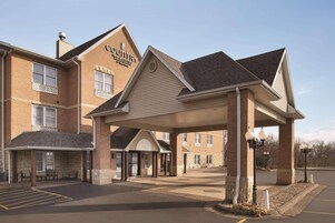 Un Country Inn & Suites con entrada techada y estacionamiento.