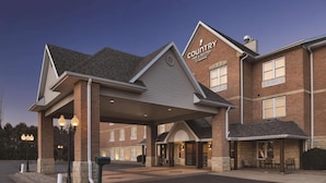 A Country Inn & Suites with a covered entrance, outdoor seating area, and a parking lot. - Country Inn & Suites by Radisson, Galena, IL (Galena)
