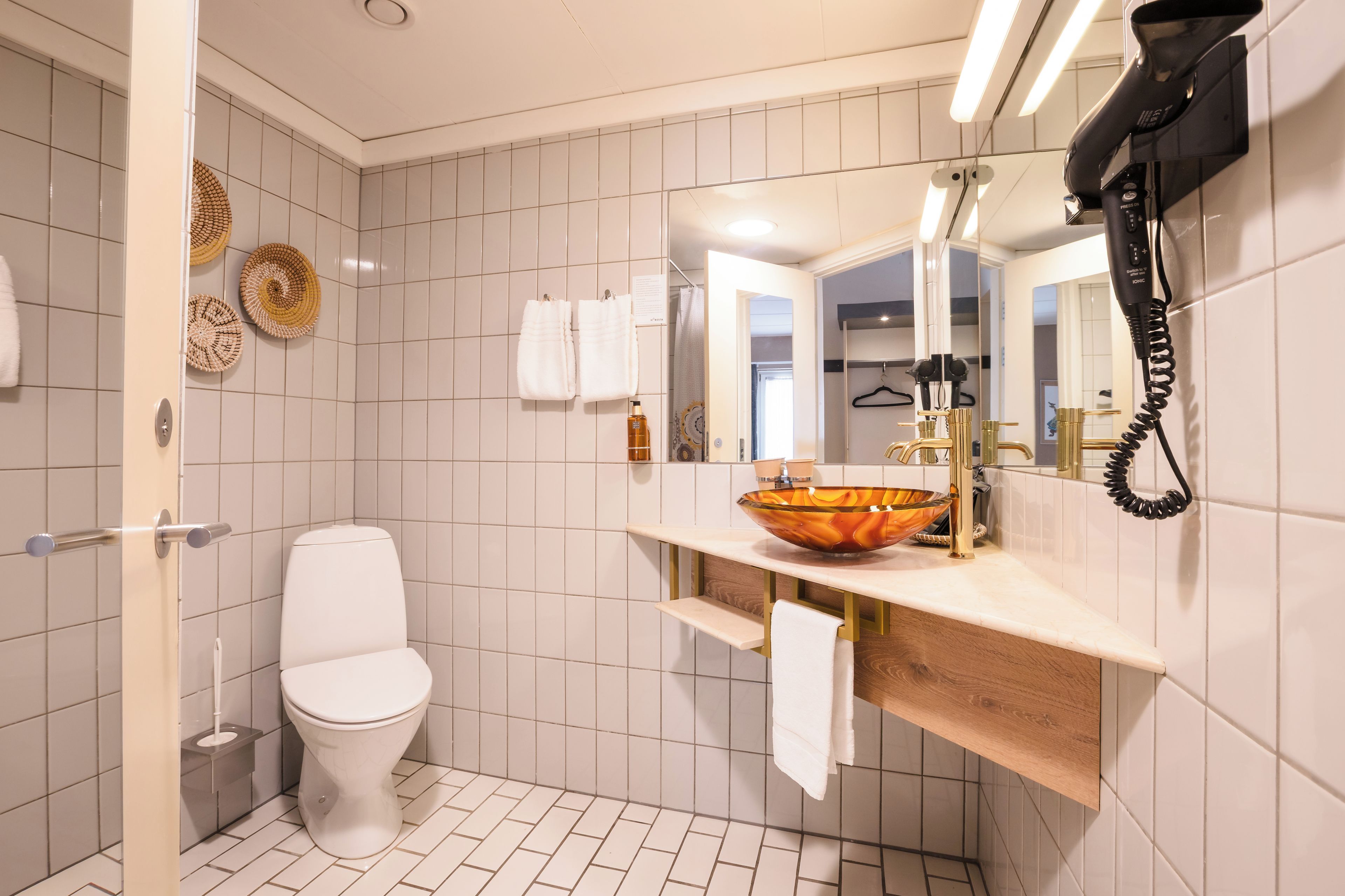 A modern bathroom with a toilet, sink, and shower.