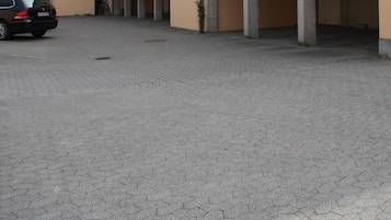 Un edificio residencial de varios pisos con un estacionamiento.