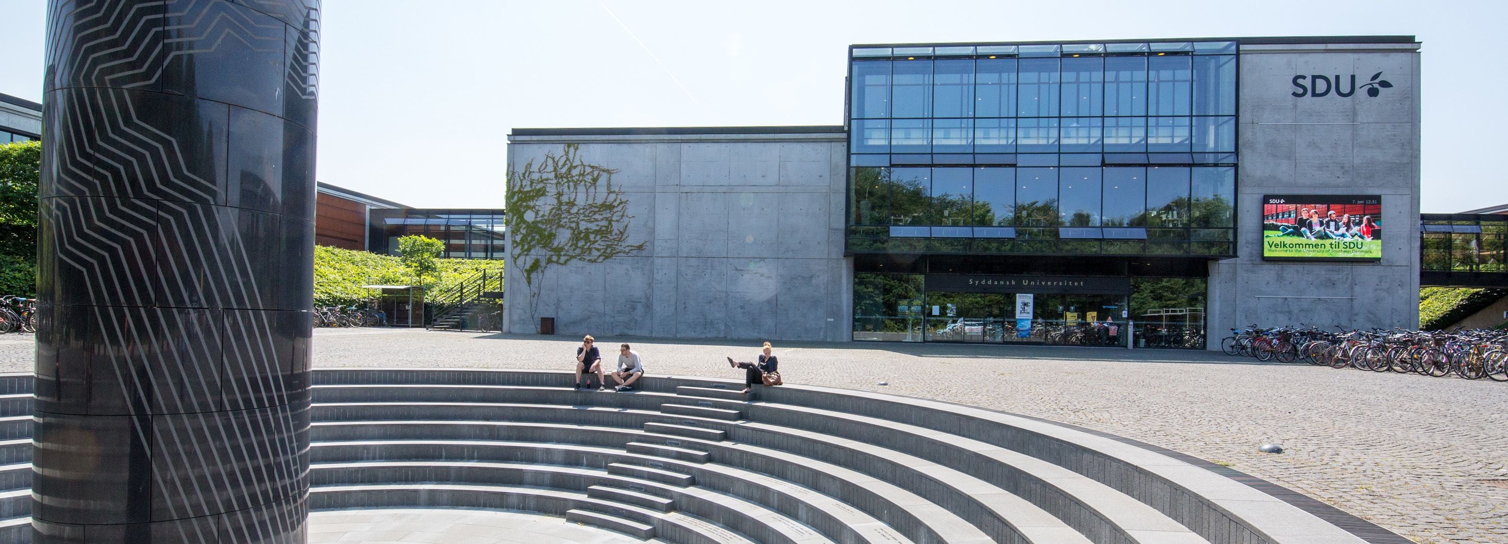 A modern building with a glass facade and the text "SDU" on the side.