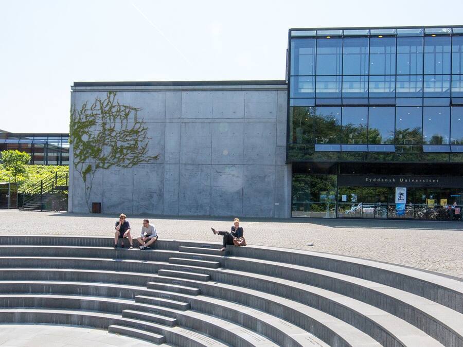 A modern building with a glass facade and the text "SDU" on the side.
