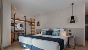 Una habitación de hotel moderna con una cama grande, mesitas de noche, un escritorio y un armario.