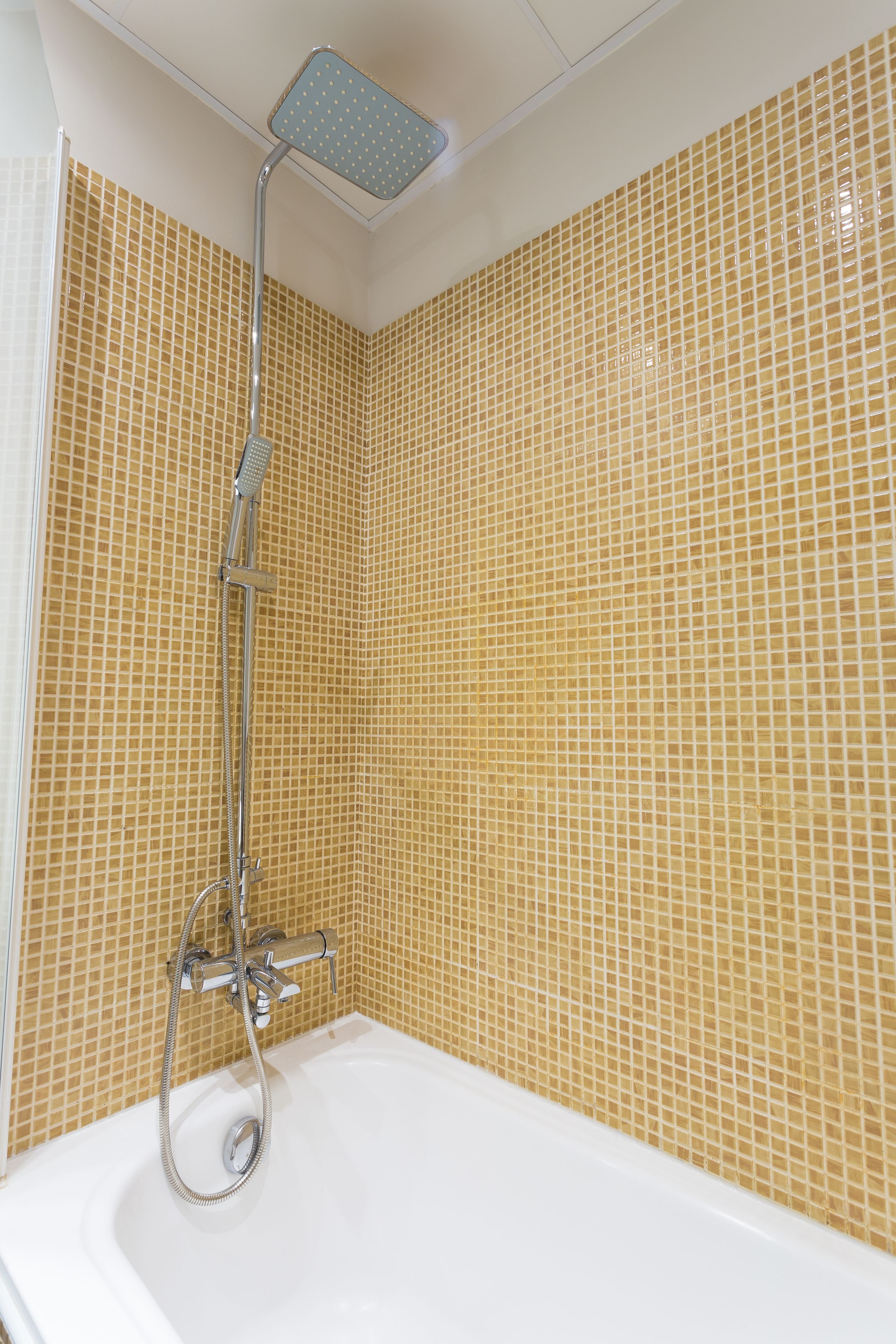 A bathroom with a shower, a bathtub, and tiled walls.