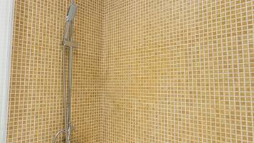 A bathroom with a shower, a bathtub, and tiled walls.