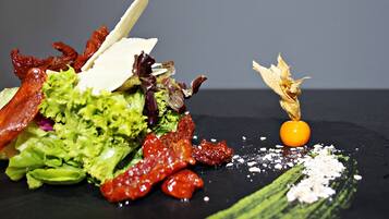 Primer plano de una ensalada gourmet con diversos ingredientes y guarniciones.