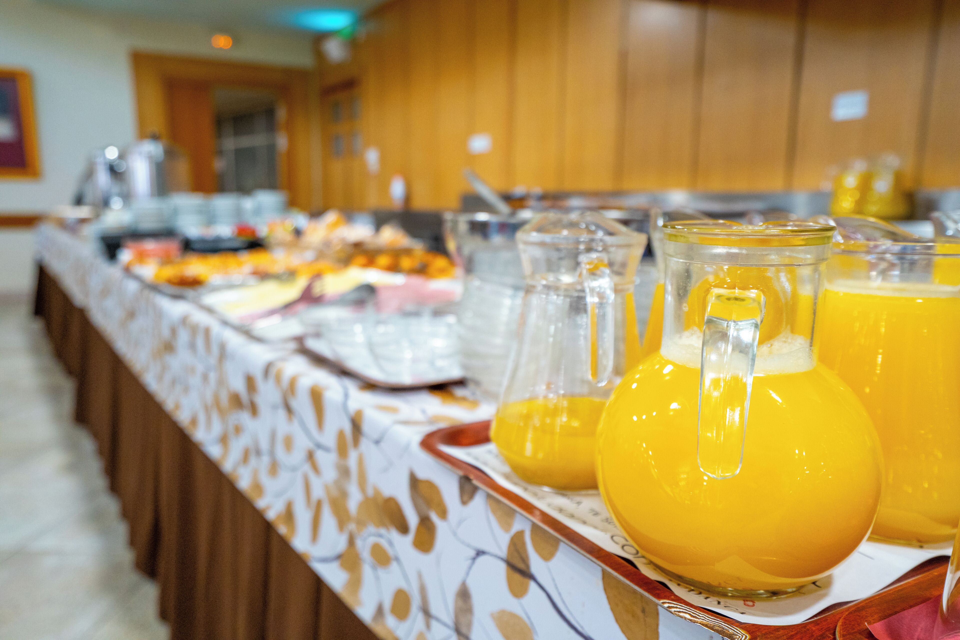 Ein Buffett mit verschiedenen Speisen und einem Krug Orangensaft.