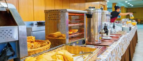 Montaje tipo bufé con diversos alimentos y una estación de café.