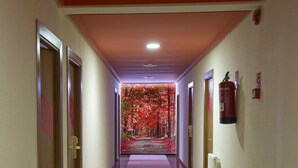 A hallway with a carpeted floor, wooden doors, and a fire extinguisher on the wall. - Tudanca Miranda (Miranda de Ebro)