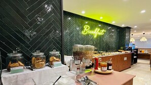 Een ontbijtbuffet met diverse keuzes, zoals ontbijtgranen, noten en smeersels, in een moderne hotelomgeving.