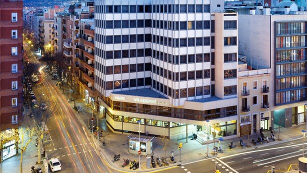 Een hotel met meerdere verdiepingen, met een modern ontwerp, een opvallende ingang en een hoekligging.