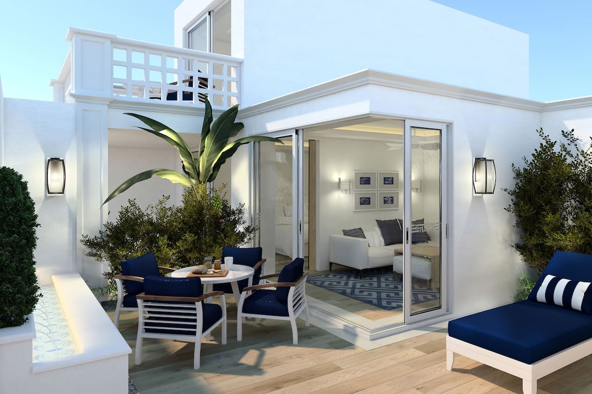 A modern outdoor living area with a dining table, chairs, and a sofa.