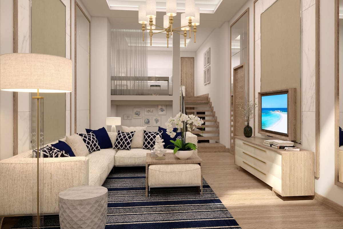 A modern living room with a sectional sofa, a coffee table, a TV, and a staircase leading to an upper level.