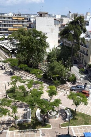 A cityscape with a central open plaza surrounded by trees and a circular monument. - Paolo (Loutraki-Agioi Theodoroi)