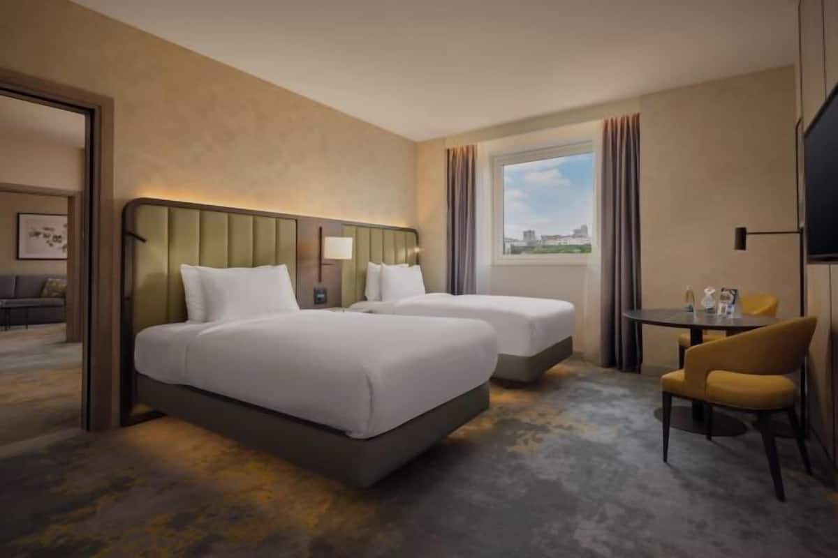 Ropa de cama hipoalergénica y caja de seguridad en la habitación