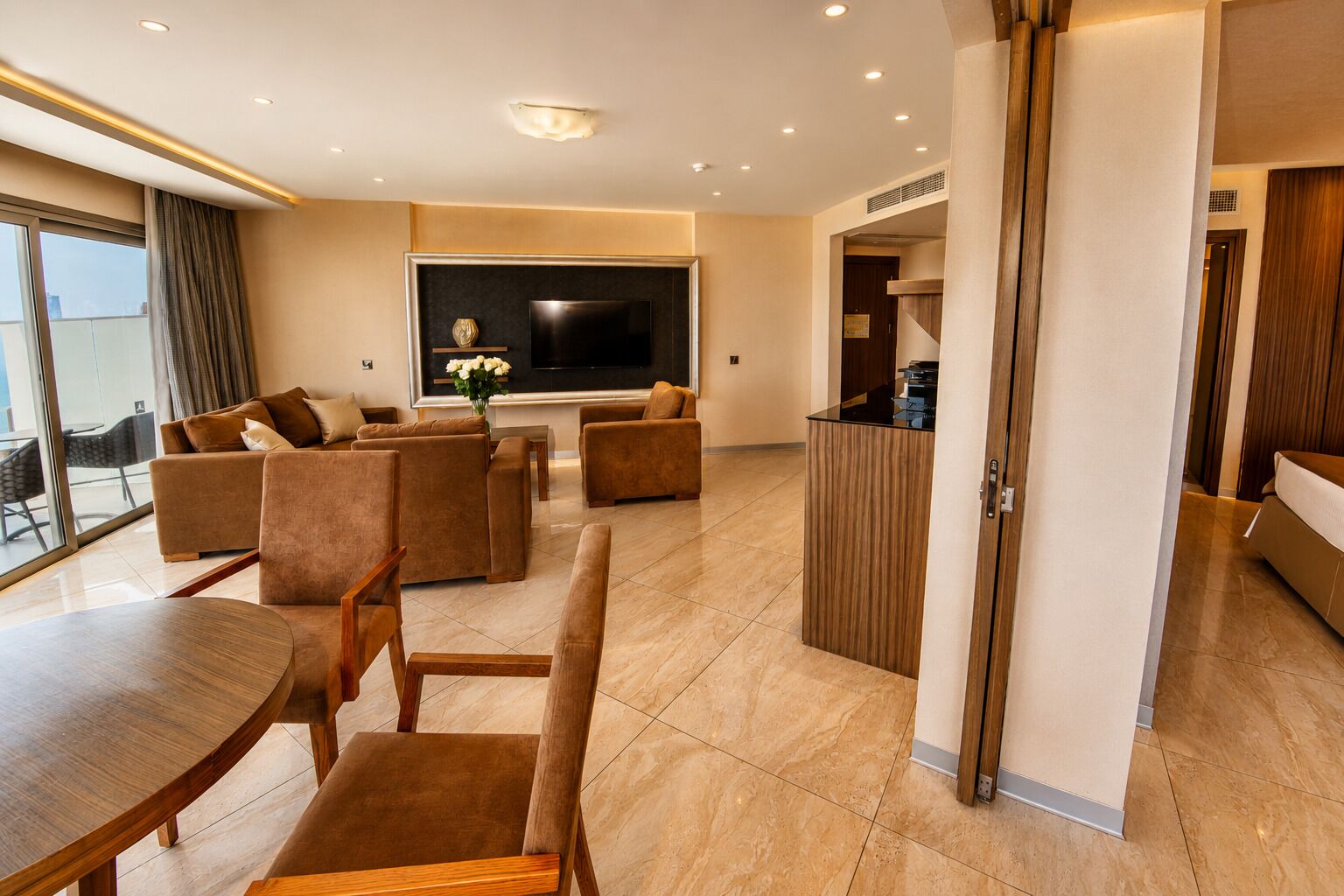 Una sala de estar moderna con un televisor de pantalla plana, sofás, una mesa de centro y un comedor.