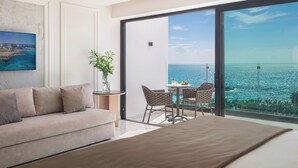 A modern room with a large sliding glass door leading to a balcony with a city view. - Adams Beach Hotel & Spa (Ayia Napa)