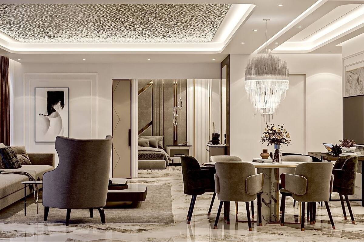 A modern, well-lit living room with a sofa, armchairs, and a dining area with a chandelier.